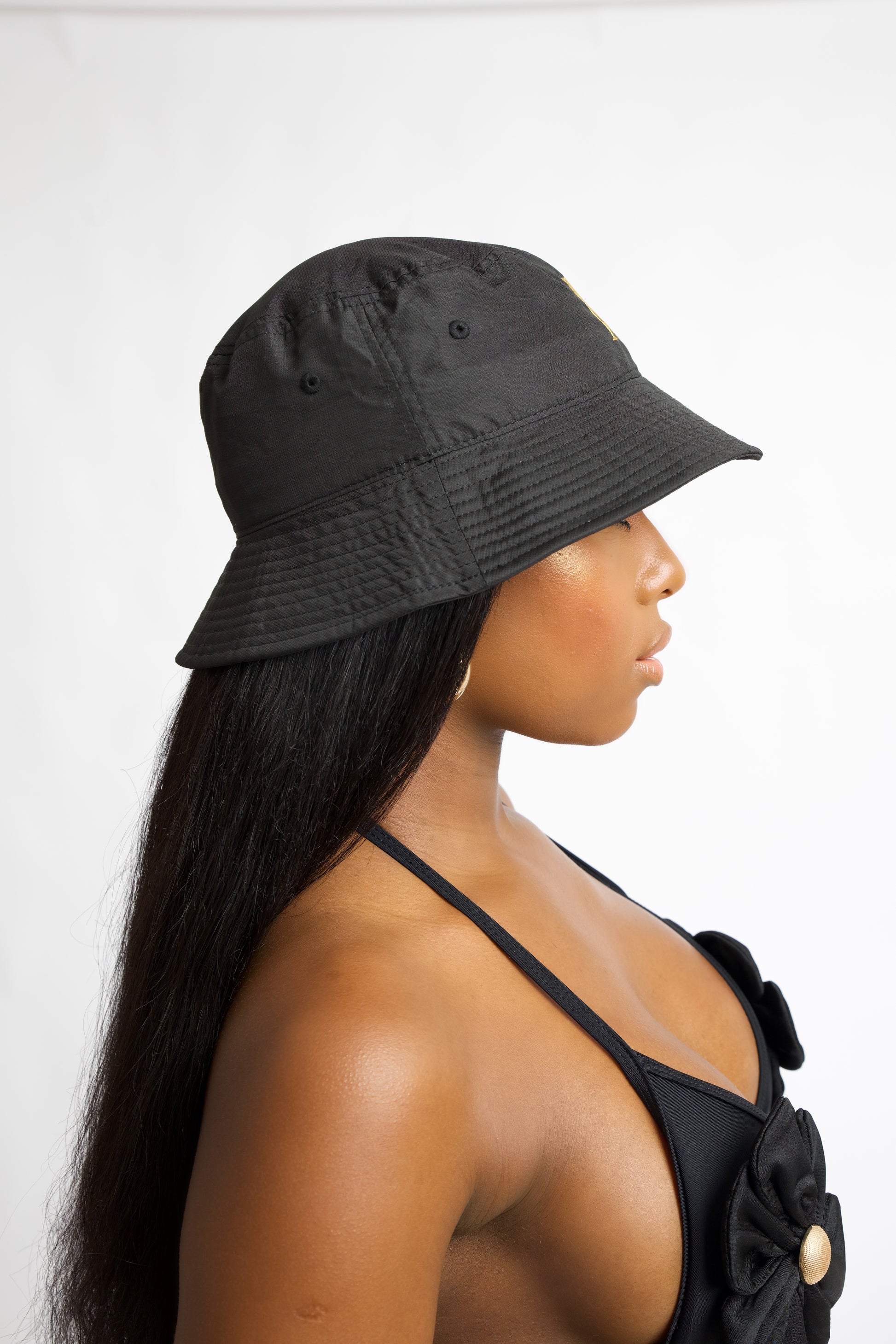Black bucket hat with gold embroidery and wide brim. Inspired by Rio de Janeiro. One size fits all. A must-have luxury resort accessory.