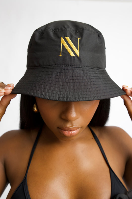 Black bucket hat with gold embroidery and wide brim. Inspired by Rio de Janeiro. One size fits all. A must-have luxury resort accessory.